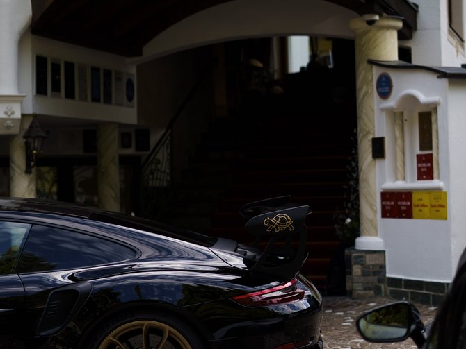 Eingang des Hotels Jagdhof mit schwarzem Sportwagen auf dem Kopfsteinpflaster