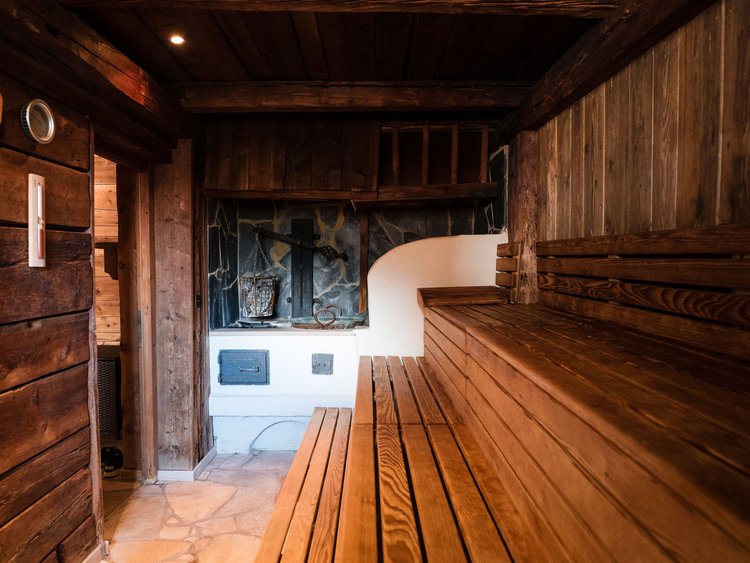 Discover the Jagdhof, Stubaital, and Tyrol Interior of wooden sauna with stone stove and wooden benches