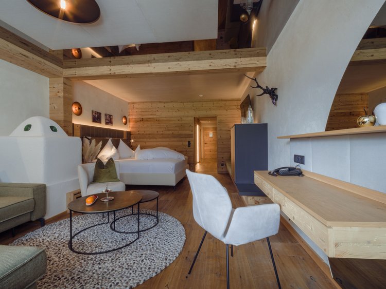 Discover the Jagdhof, Stubaital, and Tyrol Modern hotel room with wood decor, bed, rug, chairs, and desk