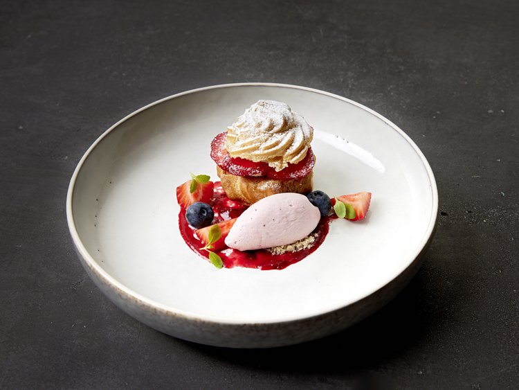 Off to the gourmet hotel in Tyrol! Delicate dessert with cream puff, strawberries, blueberries, and red sauce