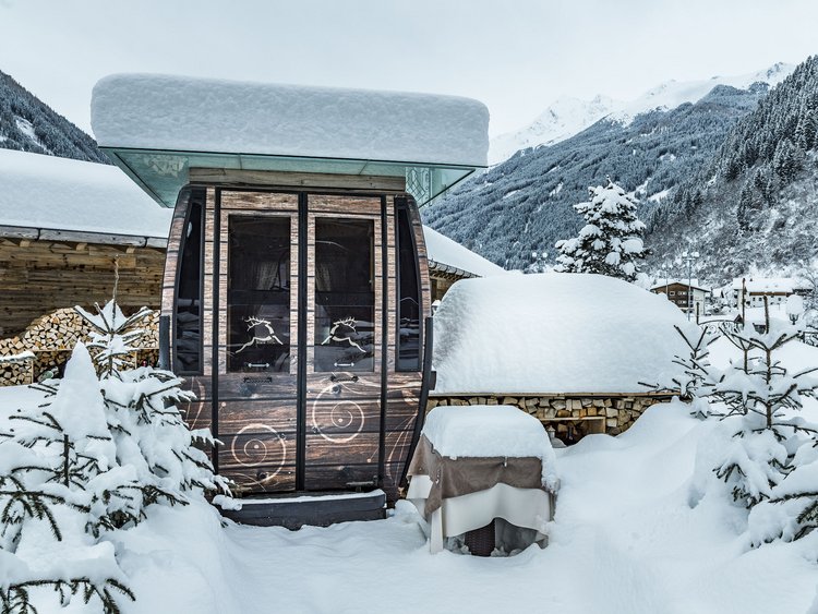 Schneebedeckte Holzkabine und Tische in winterlicher Berglandschaft