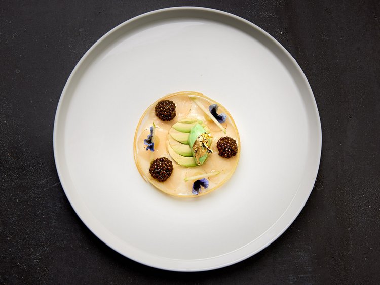 Off to the gourmet hotel in Tyrol! Gourmet dish with pearls and edible flowers on a white plate