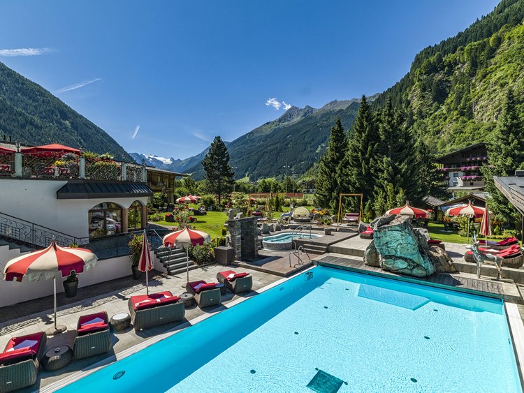 Swimming pool with loungers and mountain landscape in the background