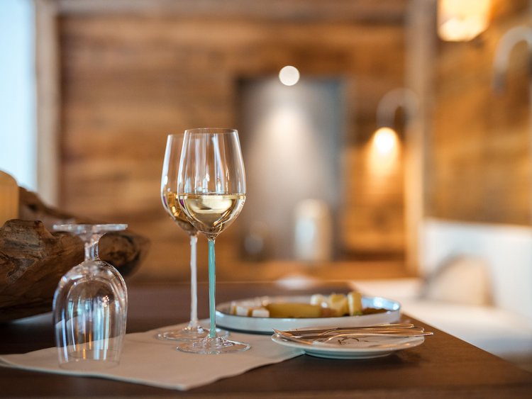 Two glasses of white wine on wooden table in cozy setting