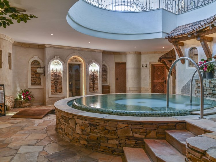 Rundes Spa-Becken mit Steinfassade in einem gemütlichen Innenraum