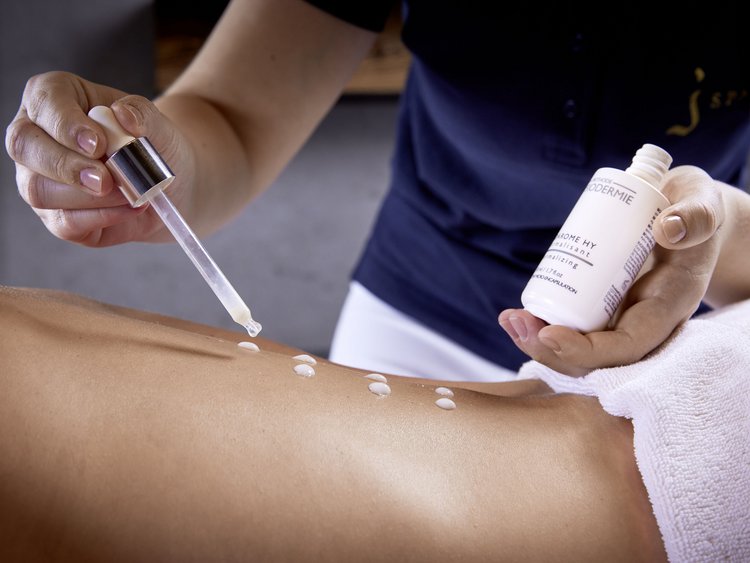 Operatore applica una lozione con pipetta sulla schiena nuda