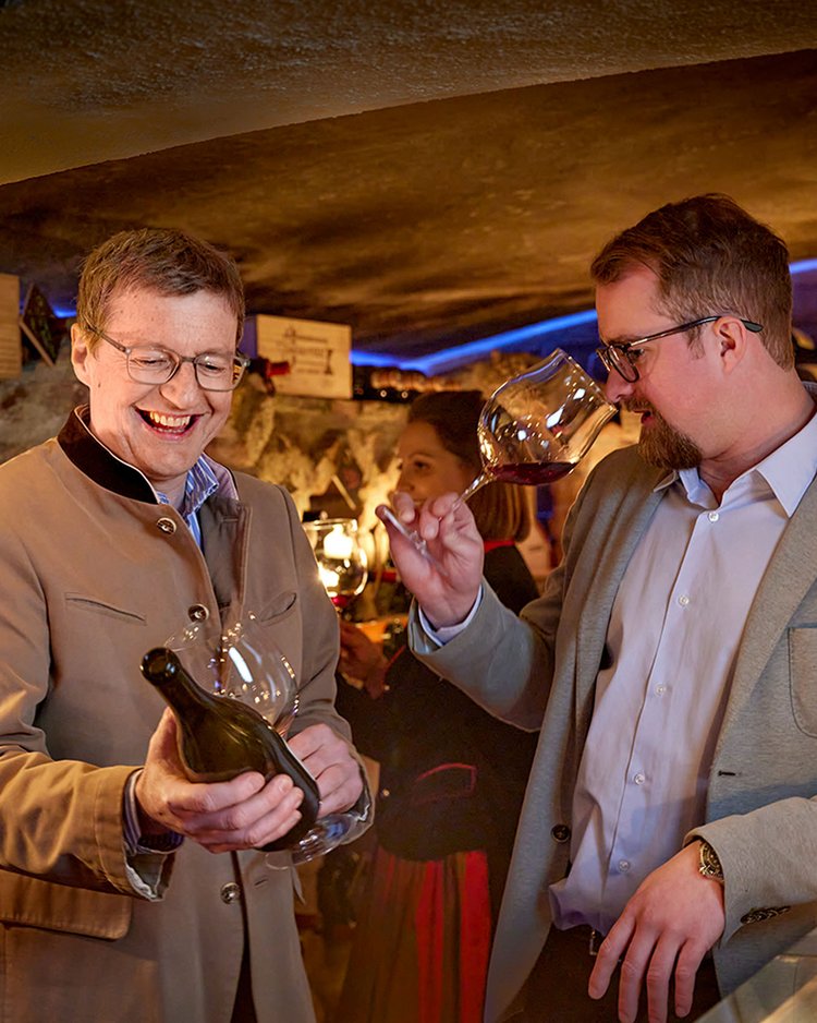 Zwei Männer probieren Wein in einem gemütlichen Weinkeller