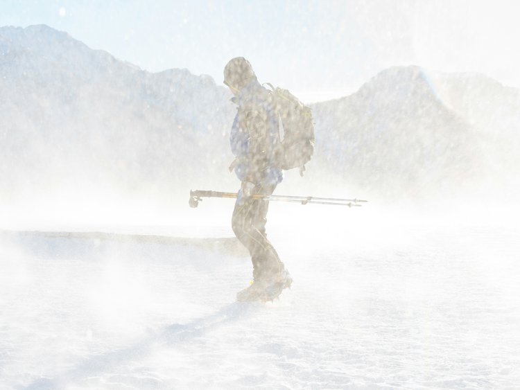 Bergsteiger bei Schneesturm mit Wanderausrüstung in den Bergen
