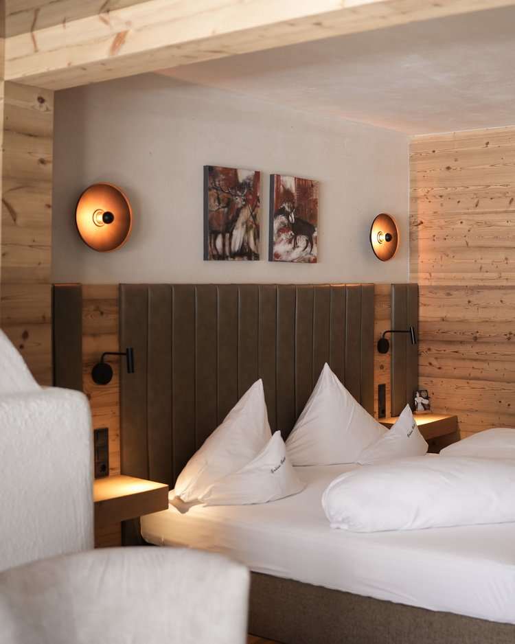 Gemütliches Schlafzimmer mit Holzwänden und Doppelbett